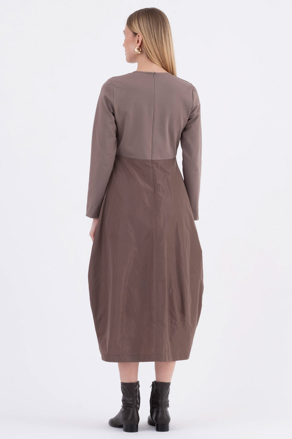 Woman wearing a brown dress with a matching jacket on a white background