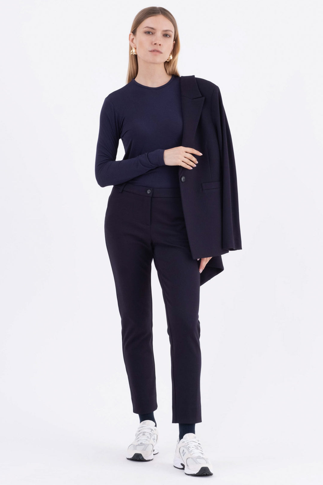 Woman wearing a navy suit with a white background
